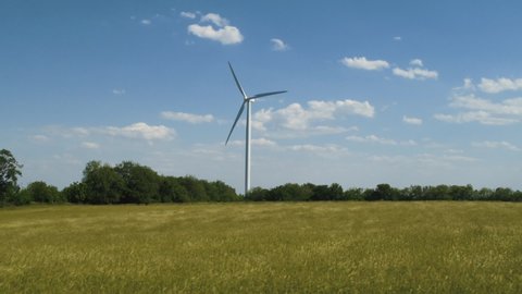 Panning shot of wind turbine in field