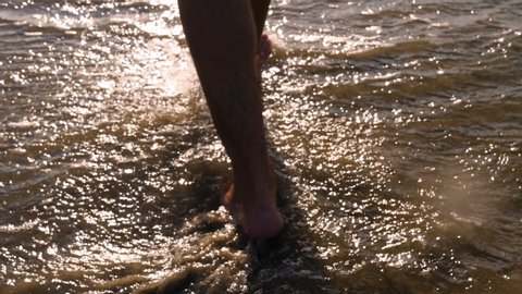 Legs Of Man Walking On Beach (Sea)
