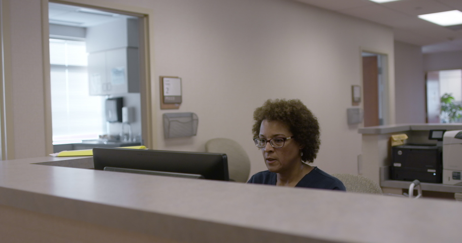 Nurse greeting couple at desk in hospital Royalty-Free Stock Footage #1033065305