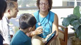Doctor with digital tablet talking to family in hospital lobby - Powered by Shutterstock - Get 15% off with code: PIKWIZARD15