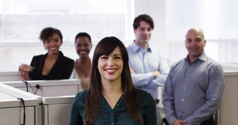 Smiling business people posing in cubicles