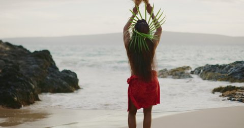 Beautiful polynesian woman performing a Tahitian hula dance on the beach