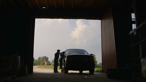 Caucasian father and son opening barn door for truck