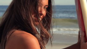 Woman holding surfboard on beach - Powered by Shutterstock - Get 15% off with code: PIKWIZARD15