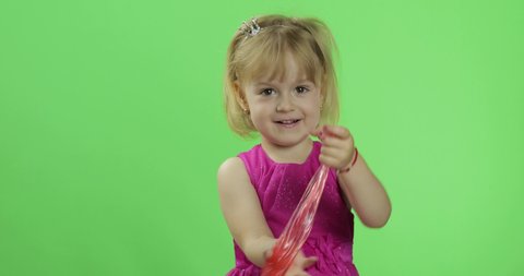 Child having fun making red slime. Kid playing with hand made toy slime. Funny kid girl. Relax and Satisfaction. Oddly satisfying blue slime for pure fun and stress relief. Green screen. Chroma Key
