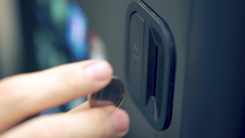 Inserting one euro coin into vending machine