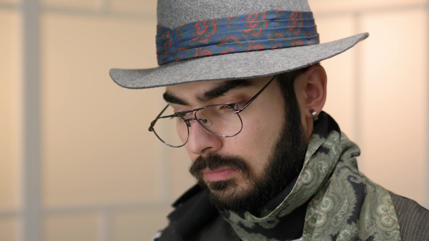 Millennial hipster portrait looking at the camera by turning his head.