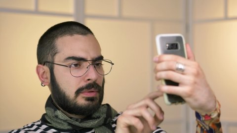 Millennial hipster using a smartphone mobile phone