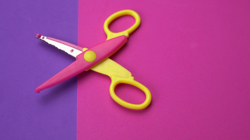 Set of a variety of wavy blade scissors for scrapbooking on colorful paper moves from right to left. Abstract minimal background with space for text.