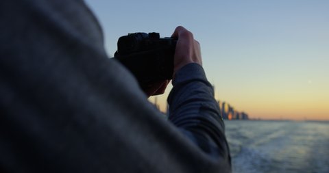 Close Up of Male Model Photographing Beautiful Sunset and Beautiful Skyscrapers and Skyline In NYC On Hudson River Moving Away From Incredible New York Sunset