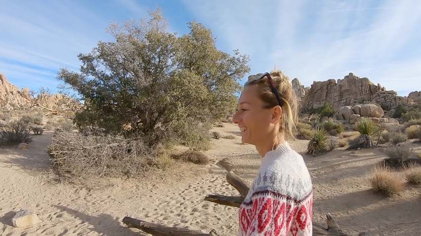 Happy young woman walking running in nature enjoying travel in beautiful places; Cheerful girl loving adventure in the desert spinning around arms outstretched- Slow motion 