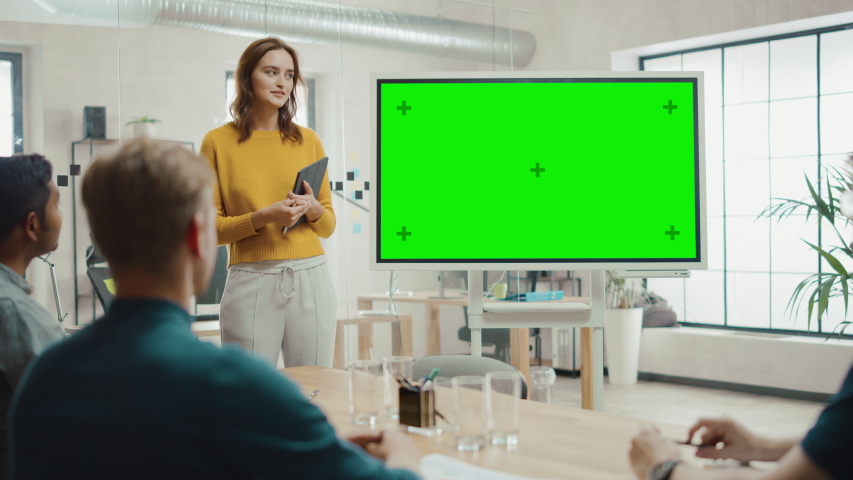 Female Project Manager Holds Meeting Presentation for a Team of Developers. She Shows Green Screen Interactive Whiteboard Device for Business Planning Concept. Young People Work in Creative Office Royalty-Free Stock Footage #1033113347