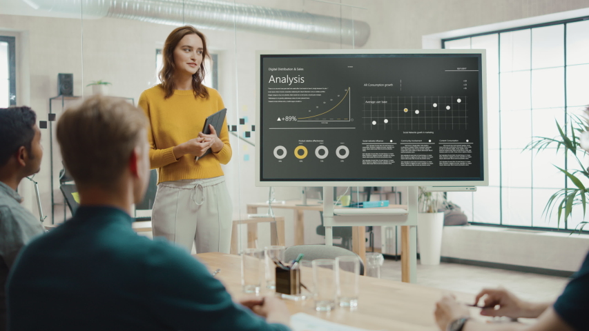 Female Chief Analyst Holds Meeting Presentation for a Team of Economists. She Shows Digital Interactive Whiteboard with Growth Analysis, Charts, Statistics and Data. People Work in Creative Office | Shutterstock HD Video #1033113362