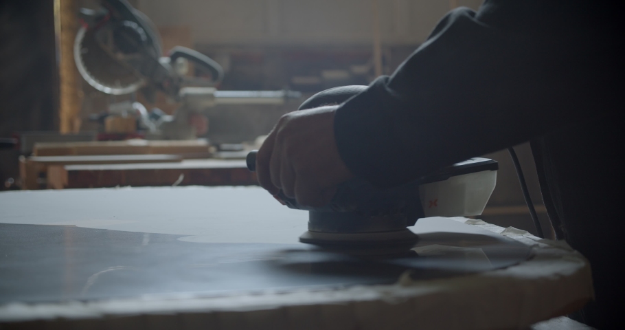 Close-up shot of grinding machine polishing the wooden board at wood factory.