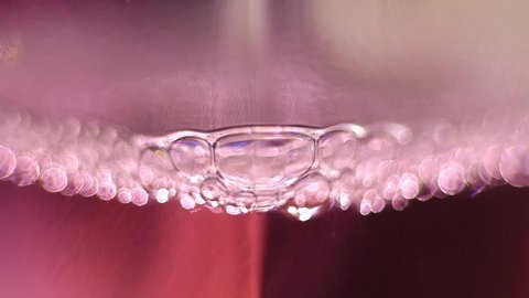 Close Up Of Exploding Air Bubbles In A Perfume Bottle.