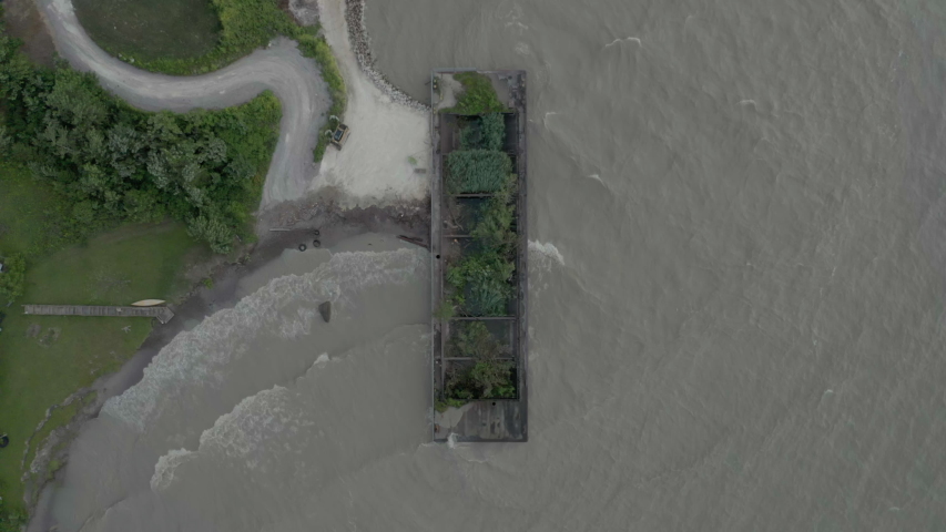 4k Aerial Footage Looking Down At a barge that is being used as a break wall to help prevent erosion, Lake Erie, Ohio, USA