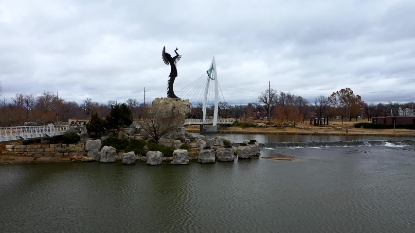Aerial video of the Keeper of the Plains near downtown Wichita, Kansas on a cloudy day.