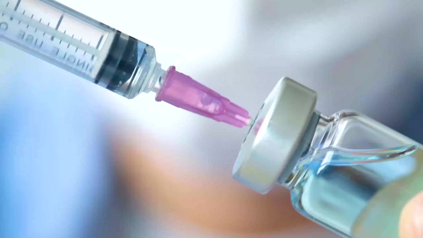 Doctor's hand holds a syringe and a blue vaccine bottle at the hospital. Health and medical concepts.
 | Shutterstock HD Video #1033148348