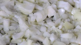 White onion sliced into small pieces, passed with olive oil in a pan with non-stick coating, video clip close-up shooting