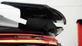 Close up photo (video) of open rear trunk spoiler, led taillights.