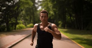 Man running Slow Motion in Park sunny day Medium shot. Sportsman Runner Athlete training 