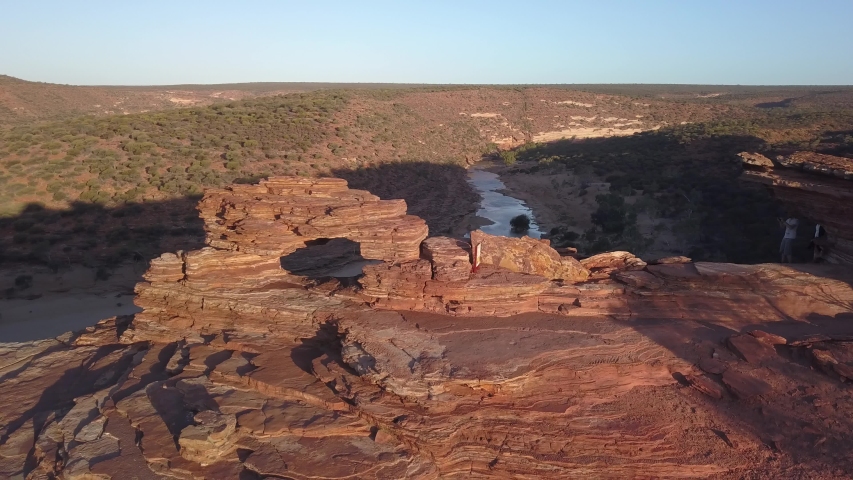 the natural window in the barren desert of the Kalbarri National Park offers a wonderful view of the valley illuminated by the red sun