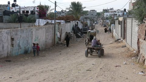Gaza City, Gaza Strip / Palestinian Territories. May 8, 2018. Bedouin district of Gaza with a dusty road, children and people walking. 