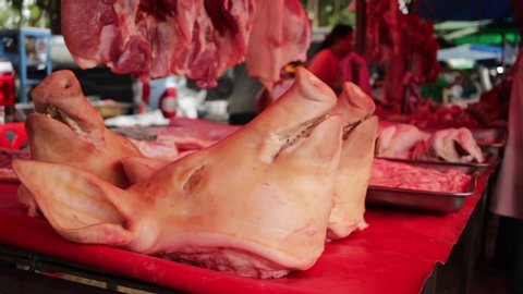 Decapitated pig head on the table of a meat vendor in Wat Bangsai temple market, Banmai, Phitsanulok
