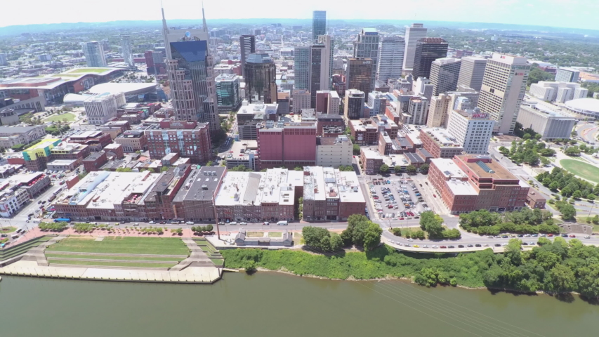 4K drone footage. Side panning left flying in downtown Nashville TN. Birds eye view. Skyline and Broadway can be seen. Streets, cars, skyscrapers, businesses, bars.