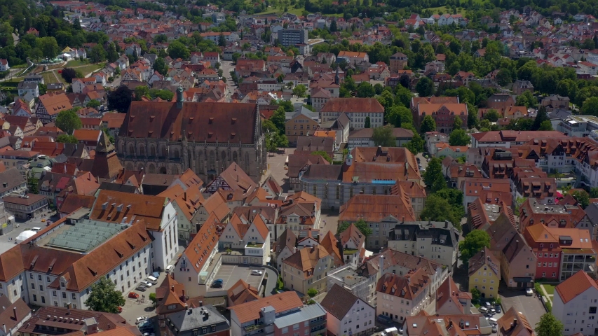 Aerial of the old part of town of Schwäbisch Gmünd in Germany.  Camera pans left and then rotates right over the city center. View of Minster of the Holy Cross Cathedral.