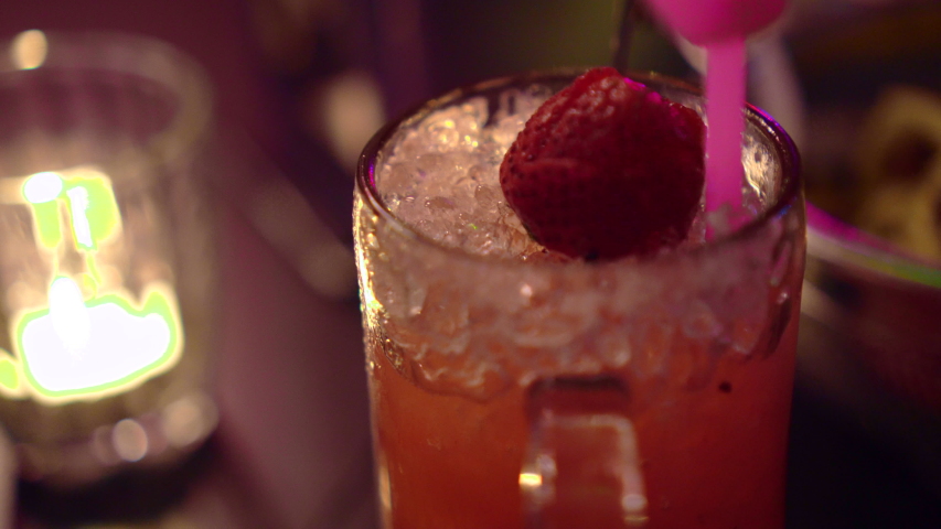 Berry cokctail drinks at night bar with candle and neon light
