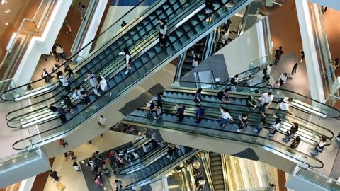 Time lapse of crowded people in shopping mall. Escalators in modern shopping mall.