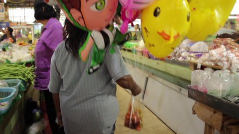 Banmai, Phitsanulok / Thailand - 12 29 2018: Tracking Shot Ballon Vendor Walking Through Banmai Fresh Market