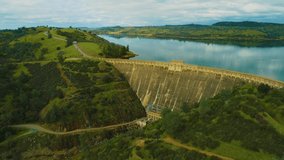 Aerial view of Dam on a Country side Green Grass Live stock Mountains and Lakes Power Company 
