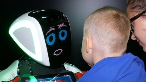 Chelyabinsk, Chelyabinsk region / Russia: 07.10.2019: Communication with robot. Mother and baby communicate with robot, the robot responds to the greeting and supports the conversation with emotions.