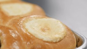 hot kolaches on a tray get sprinkled in slow motion. Kolaches fresh from the oven are sprinkled in this slow motion clip.