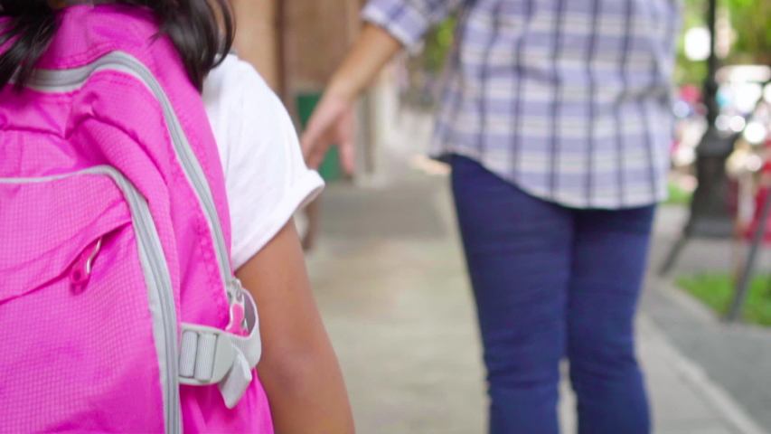 Mother holding hand of little daughter with backpack and walking going to school outdoors. Close up, Back to school concept, Slow motion. Royalty-Free Stock Footage #1033216868