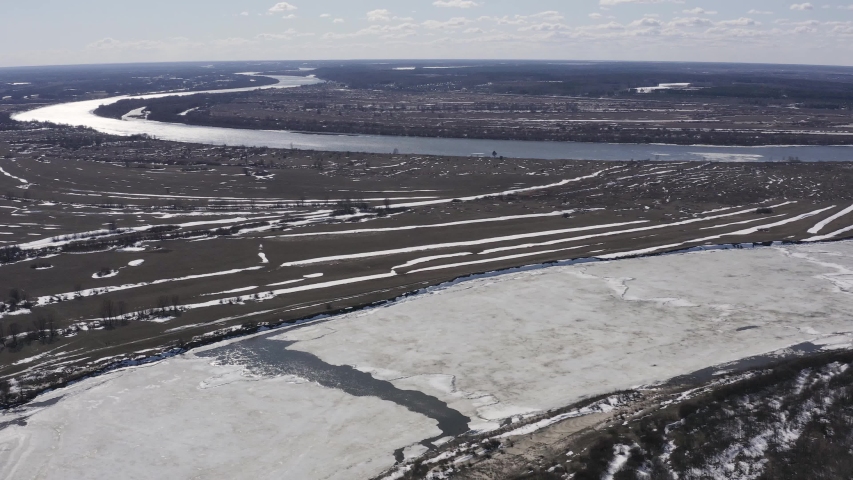Flying drone over the ice floating on the river Oka