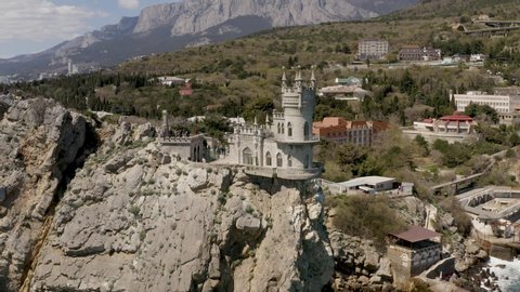 Aerial drone footage of Castle Swallow's Nest on a rock at Black Sea, Crimea. Castle is located in the urban area of Gaspra, Yalta