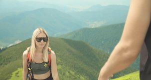 Happiness couple tourist traveler handshake and walking on the top of mountain in summer sunny day under sun light. Beautiful mountains landscape view. 4K slow motion video