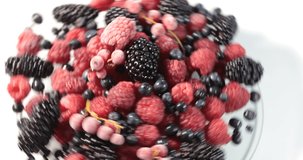 red black wild forest berries raspberries spinning on glass tray interesting alternative compositions made from different alternative angles 4K video shot wonderful perfect color tones conceptual wild