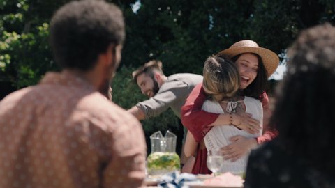 happy friends arriving at garden party celebration hugging enjoying friendship reunion gathering sitting at table with healthy food sharing weekend picnic together 4k