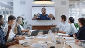 group of business people having conference call meeting in boardroom team leader man chatting to colleagues using online video chat on tv screen discussing ideas in office 4k