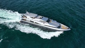 Aerial drone tracking video of luxury yacht cruising in high speed deep blue open ocean sea