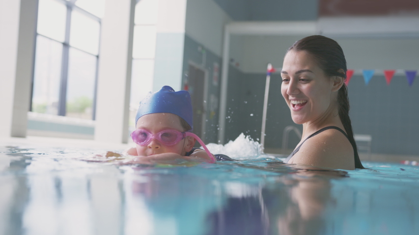 Female Swimming Coach Giving Girl Holding Float Lesson In Pool Royalty-Free Stock Footage #1033265207