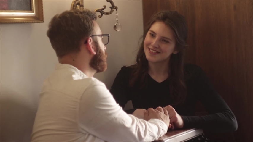 Close-up of young beautiful  female and handsome man sitting , talking and laughing at home, man and woman having relationships, real emotions. family love. Love and touching story. Romantic moments