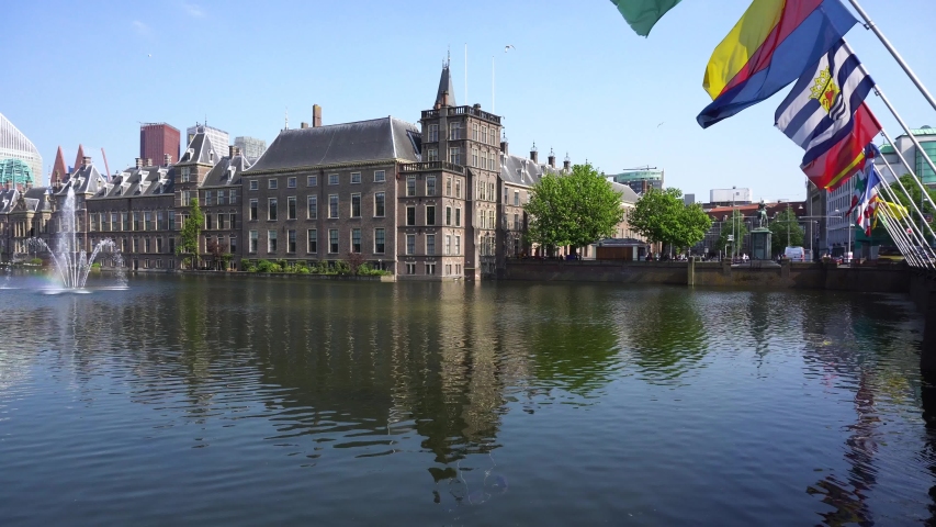 Dutch Parliament with reflections in pond and flags, The Hague at spring with flowers, Holland