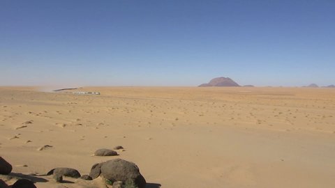 View at passing world longest train in the desert of Sahara with famous monotith Ben Amira in the background