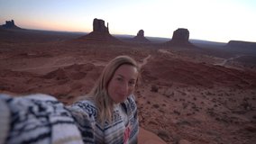 Young woman taking selfie video at Monument Valley in USA; Girl having fun on vacations enjoying nature and Navajo reserve- 4K video 