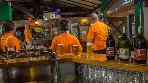 DOMZALE, SLOVENIA - 16. JULY 2018 A group of supporters is drinking lots of bier and are watching a basketball game in the bar. They're supporting their team.